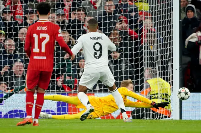 iverpool goalkeeper Caoimhin Kelleher (rear) saves a penalty from Real Madrid's Kylian Mbappe (right) during the UEFA Champions League, league stage match at Anfield, Liverpool.