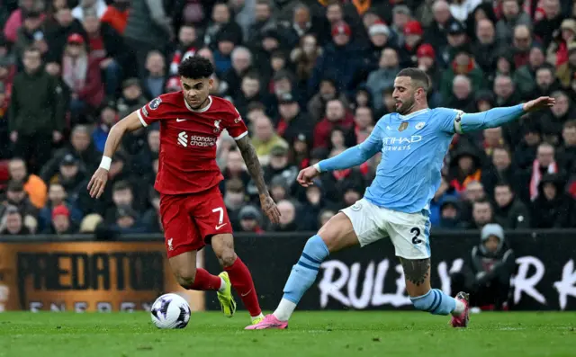 Luis Diaz of Liverpool challenges Kyle Walker of Manchester City.