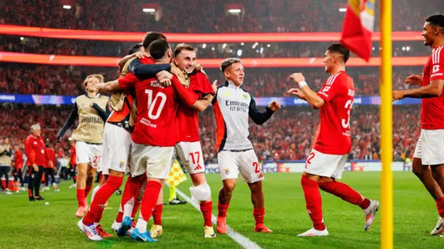 Benfica team players celebrate after scoring a goal.