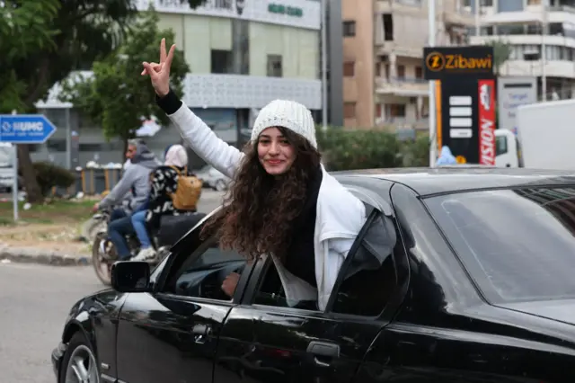 A Lebanese girl gestures as she arrives in the southern Lebanese city of Sidon on November 27, 2024, as displaced people make their way back to their homes in the south of Lebanon after a ceasefire between Israel and Hezbollah took effect.