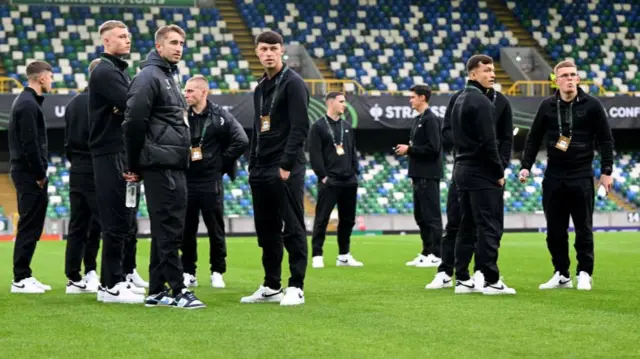 Players of Larne FC inspect the pitch prior to a UEFA Conference League match