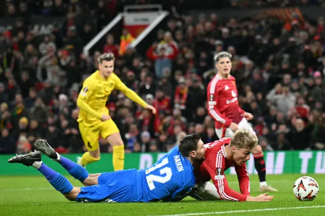 Rasmus Hojlund (2R) tackles Bodoe/Glimt's Russian goalkeeper #12 Nikita Haikin