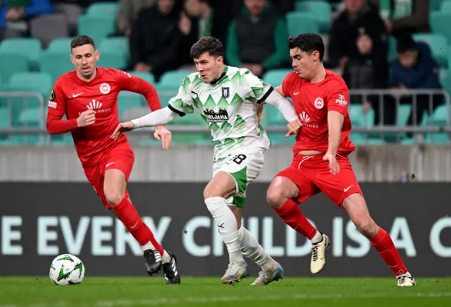 Marko Brest of Olimpija runs with the ball against Larne