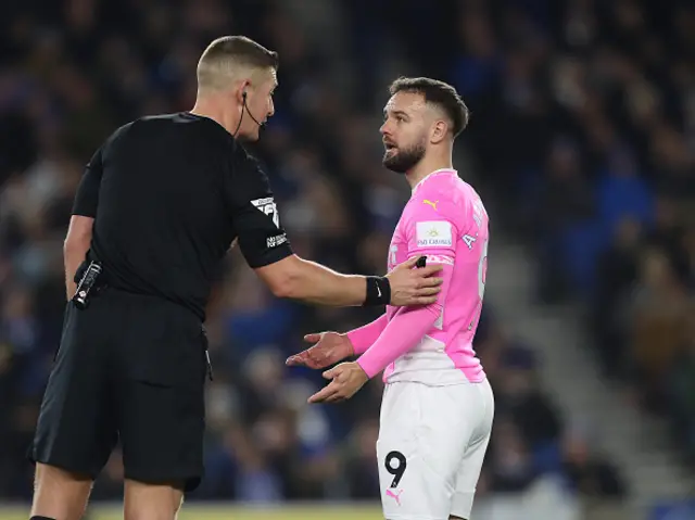 Referee, Robert Jones speaks to Adam Armstrong