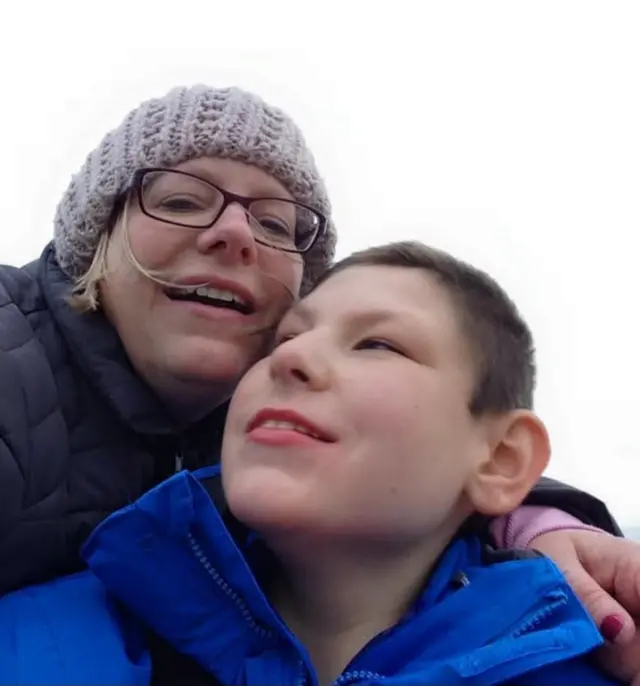 Ruth Leech is pictured with her son. They're dressed in winter coats and are standing outside.