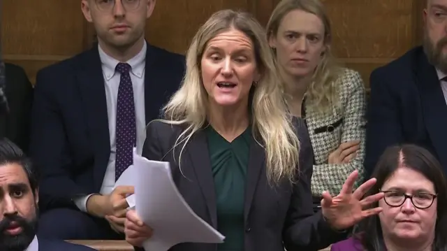 Kim Leadbeater speaking to House of Commons from the benches with sheets of paper in her right hand