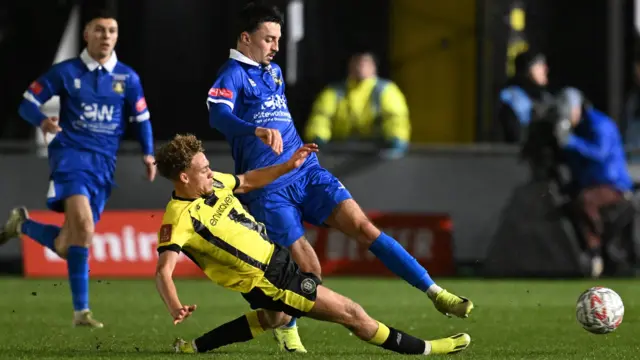 Stephen Duke-McKenna, of Harrogate Town, and Joe Stacey, of Gainsborough Trinity, challenge for the ball