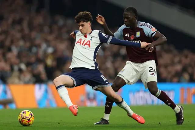 Archie Gray (L) vies with Aston Villa's Belgian defender #24 Amadou Onana (R)