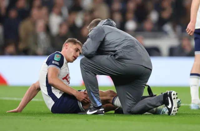 Micky van de Ven of Tottenham Hotspur is treated for an injury