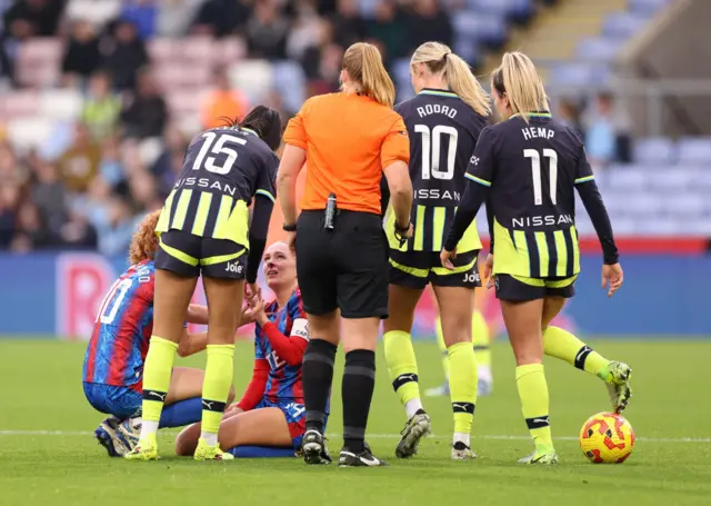 Blanchard sits on the floor surrounded by players after a collision