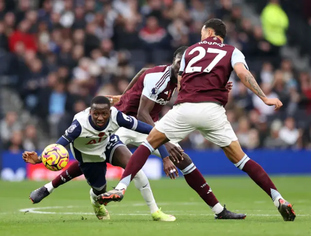 Pape Matar Sarr of Tottenham Hotspur battles for possession under pressure from Morgan Rogers