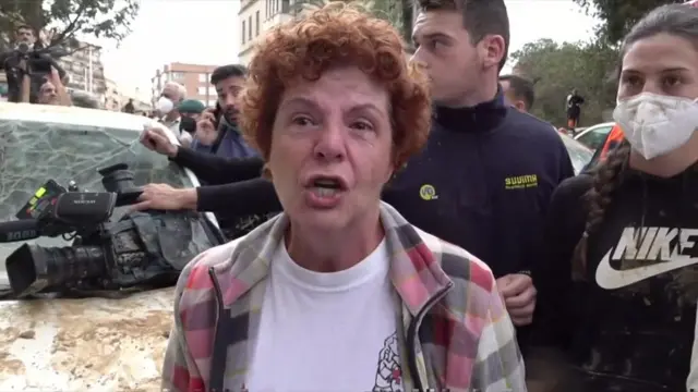 Julia Chisert next to a smashed car speaking in Paiporta