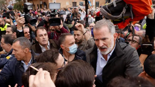 Spain's King Felipe (R) tries to calm down angry citizens as he visits Paiporta