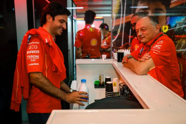 Carlos Sainz making a coffee with Fred Vasseur watching