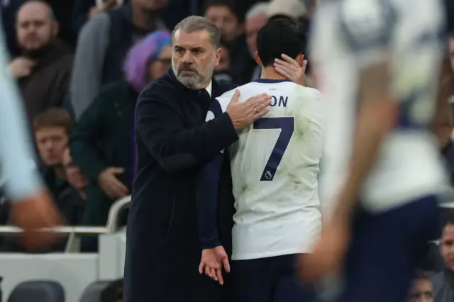 Tottenham Hotspur's Greek-Australian Head Coach Ange Postecoglou (L) consoles Tottenham Hotspur's South Korean striker #07 Son Heung-Min