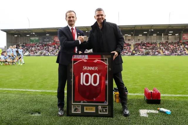 Skinner is presented with a '100' shirt to mark his 100th game in charge