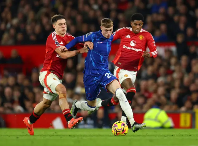 Chelsea's Cole Palmer in action with Manchester United's Manuel Ugarte and Marcus Rashford