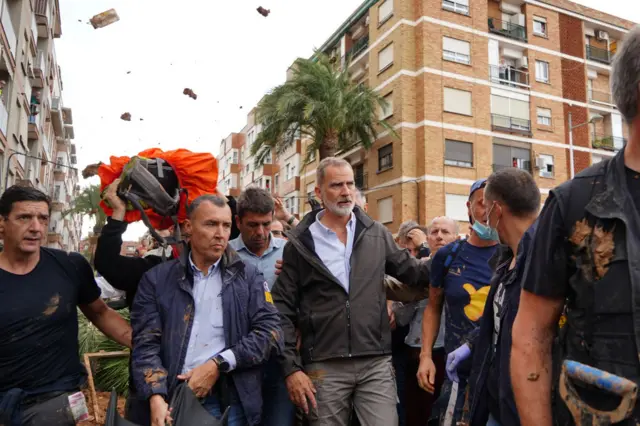 King Felipe with a crowd and objects flying overhead