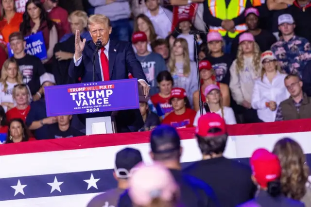 Donald Trump at a rally in North Carolina on Saturday 2 November. He's speaking at the podium with a crowd behind and