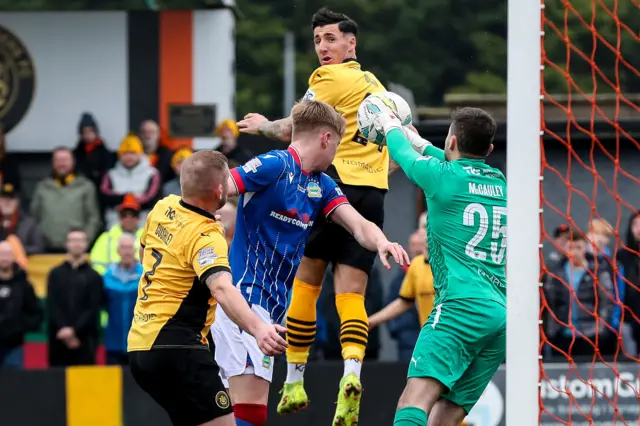 Ben McCauley gathers to avert the danger for the home side at Taylors Avenue