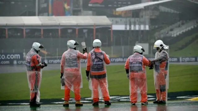 Marshals check the racetrack before the qualifying session for the Formula One Sao Paulo Grand Prix