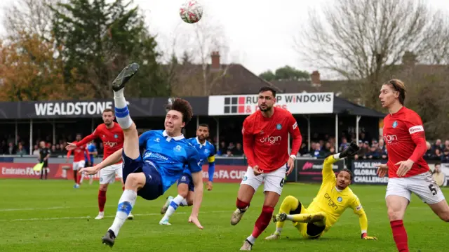 Wealdstone's Jack Cook sends the ball back into the Wycombe box with a spectacular overhead kick