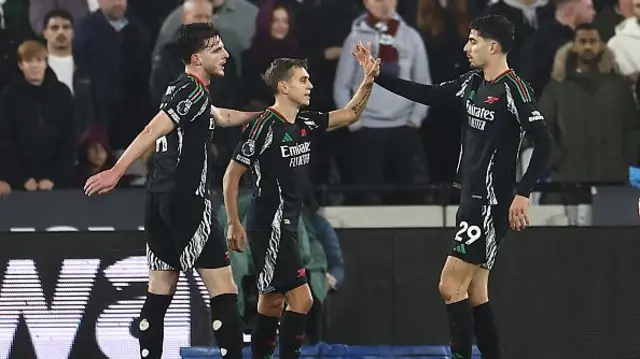 Leandro Trossard (C) celebrates with teammates.