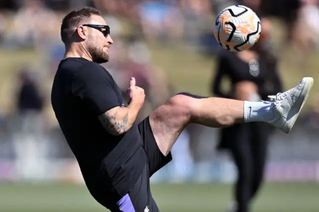 Brendon McCullum kicking a football