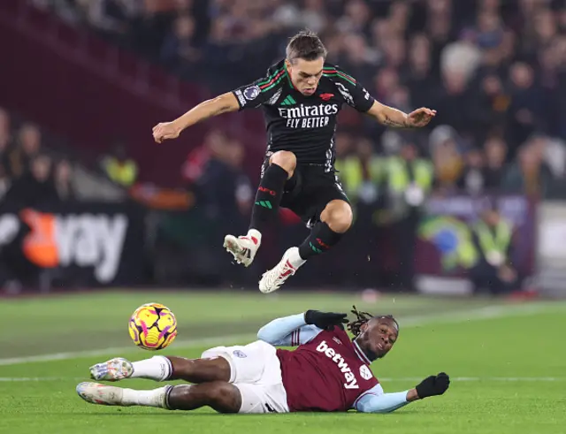 Leandro Trossard of Arsenal jumps over the challenge from Aaron Wan-Bissaka