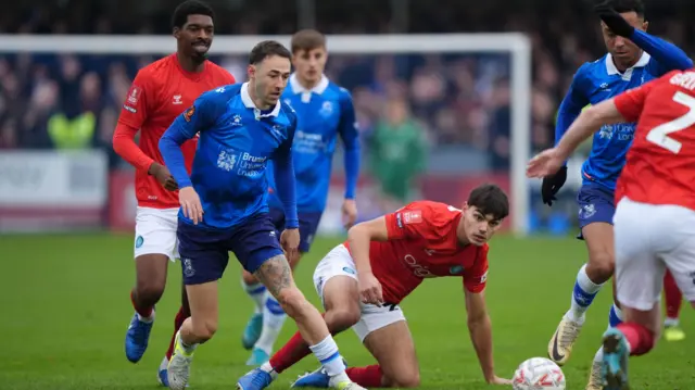 Wealdstone's Sam Ashford challenges Wycombe Wanderers' Declan Skura