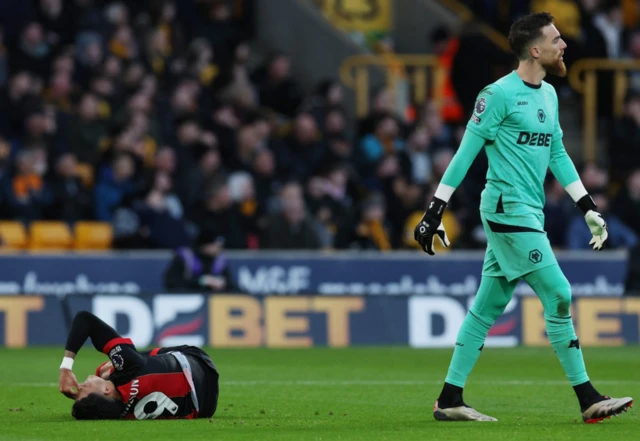 AFC Bournemouth's Evanilson reacts after sustaining an injury as Wolverhampton Wanderers' Jose Sa looks on