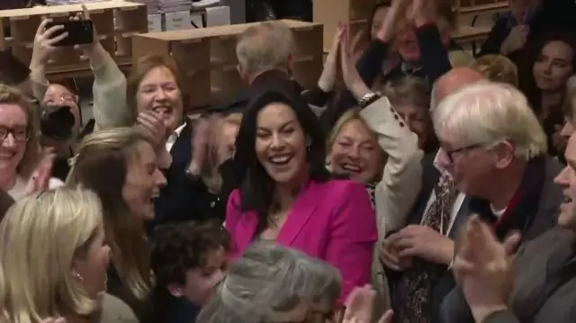 A crowd of people smiling and clapping