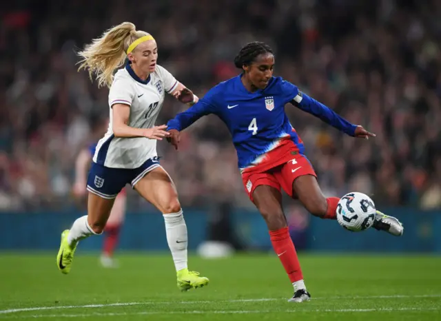 Naomi Girma of United States makes a pass whilst under pressure from Chloe Kelly of England