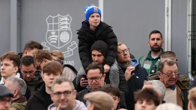 A young Wealdstone fan sits on his dad's shoulders at Grosvenor Vale