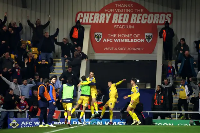 Dagenham players celebrate going 2-1 up at AFC Wimbledon