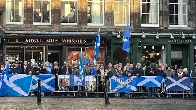 Supporters who have draped Saltire flags over the barriers outside St Giles' Cathedral