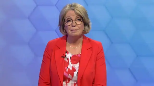 Mary Coughlan wearinga red blazer with a red and white red flower top