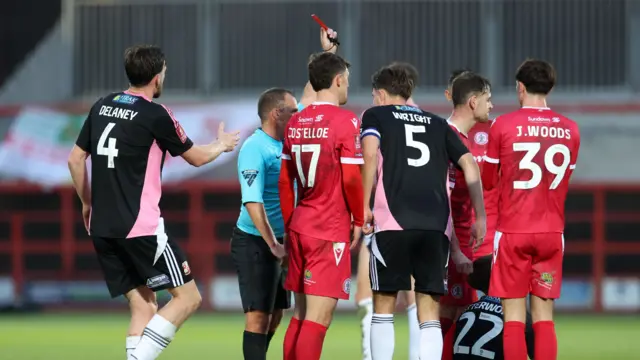 Swindon's Danny Butterworth is shown a red card by referee Geoff Eltringham