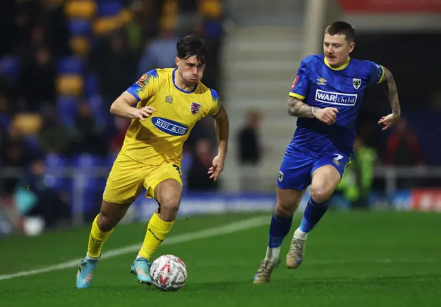 Dagenham's Oscar Rutherford takes on AFC Wimbledon's James Tilley