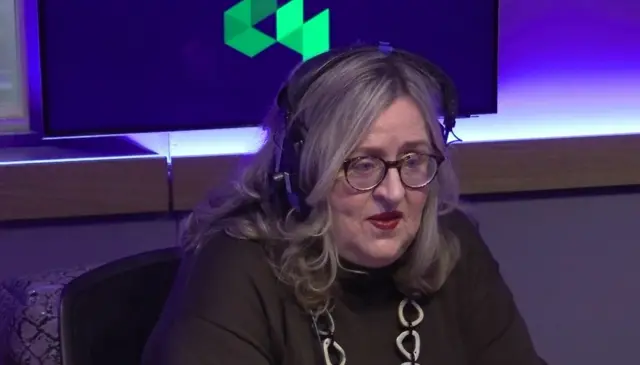 A woman, sitting in a radio studio