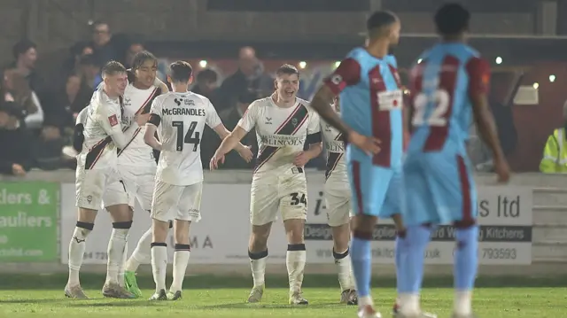 Lincoln City players celebrate with Jovon Makama