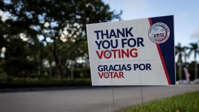 A sign is seen outside a polling station at Palm Beach County Library during early voting in the presidential election