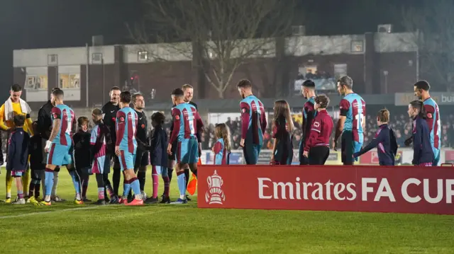 Chesham players gather prior to kick-off in their FA Cup tie against Lincoln