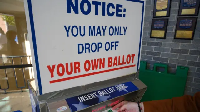 A voter uses a ballot drop box at the Bucks County Administration building voting on demand and ballot drop center in Doylestown, Pennsylvania, on October 31, 2024.