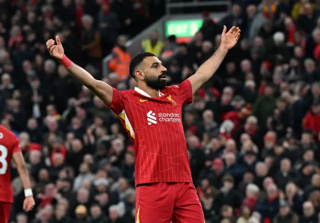 Mohamed Salah holding his arms high in celebration