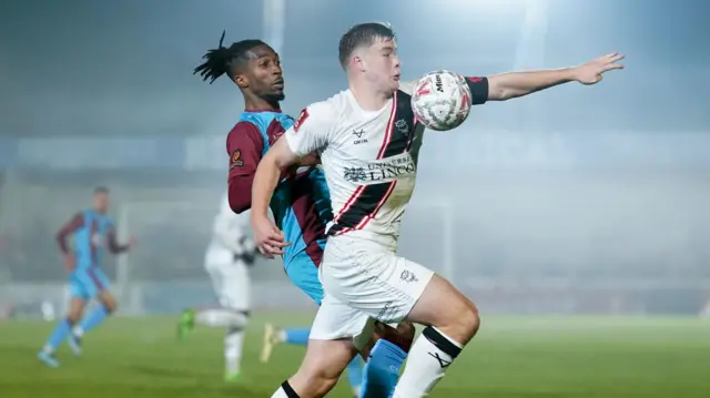 Lincoln's Freddie Draper tries to get past Chesham United's T’Sharne Gallimore