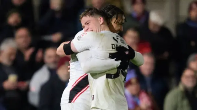 Lincoln's Jovon Makama is hugged by a team-mate after scoring at Chesham United