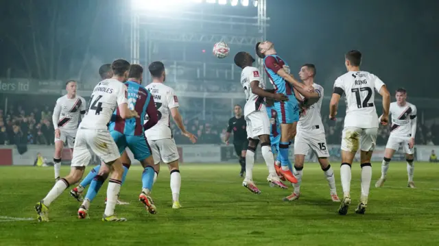 Lincoln City's Tendayi Darikwa and Chesham United's Mitchell Weiss compete for an aerial ball