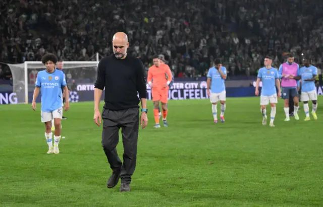 Guardiola trudges off the pitch ahead of the City players