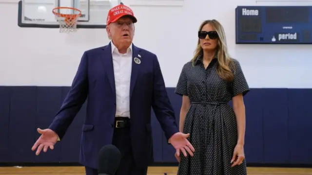 Donald Trump and Melania Trump stood as he talks